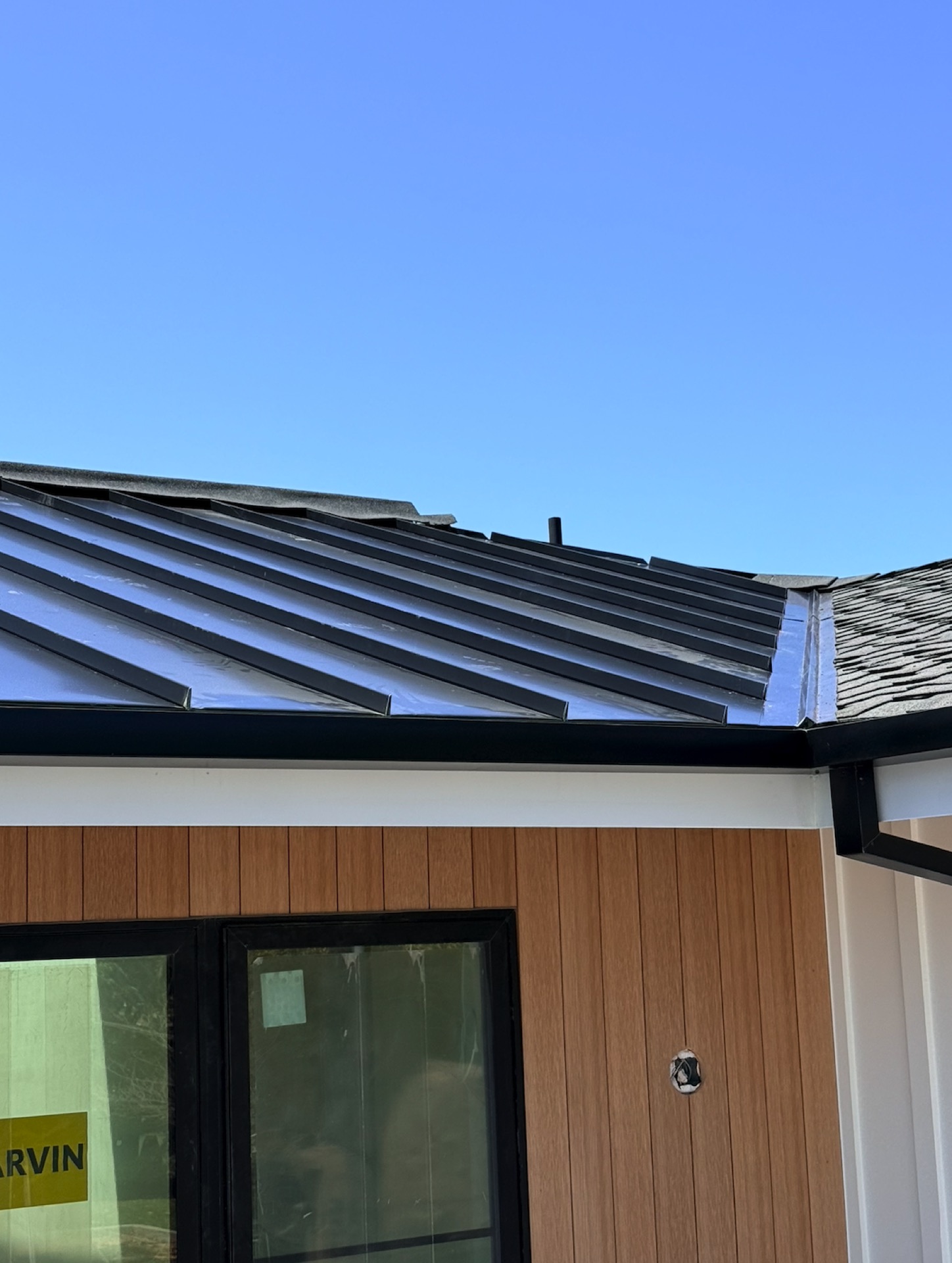 Black metal roofing and gutter detail on a modern home